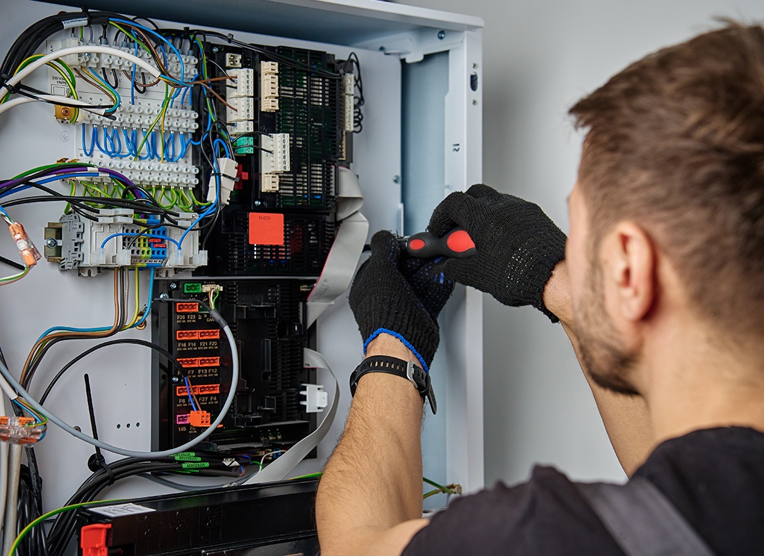 Insurance by Industry - HVAC Tech repairing a Control Panel